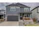 Charming two-story home with a modern gray exterior, a covered porch, and a two car garage at 635 Silver Rock Trl, Castle Rock, CO 80104