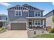 Charming two-story home featuring a well-manicured front yard, inviting porch with seating, and attached two car garage at 635 Silver Rock Trl, Castle Rock, CO 80104