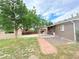 Brick home with a large backyard featuring a shed, patio and mature tree at 245 Miller Ave, Brighton, CO 80601
