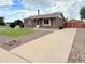 Charming brick home with a well-manicured lawn and long driveway with a detached garage at 245 Miller Ave, Brighton, CO 80601