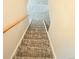 Carpeted staircase in a neutral color leading to the upper level of the home at 245 Miller Ave, Brighton, CO 80601