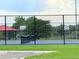 Community tennis court, enclosed, with a shelter and park in the distance at 245 Miller Ave, Brighton, CO 80601