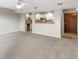 Spacious living room with carpet, open to kitchen, and access to private balcony at 12565 Sheridan Blvd # 208, Broomfield, CO 80020