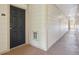 Well-lit hallway with clean white walls leading to a unit with a secure black door at 5726 N Genoa Way # 301, Aurora, CO 80019