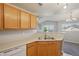 Inviting kitchen with wood cabinets, stainless steel sink, and modern lighting fixture at 5726 N Genoa Way # 301, Aurora, CO 80019