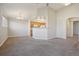 Bright living room with gray carpet, neutral walls, and open layout to the kitchen and hallway at 5726 N Genoa Way # 301, Aurora, CO 80019