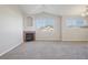 Cozy living room featuring a fireplace, vaulted ceiling, and large windows for ample natural light at 5726 N Genoa Way # 301, Aurora, CO 80019