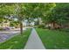 A serene street view showcasing lush greenery, a sidewalk, and well-maintained landscaping at 5726 N Genoa Way # 301, Aurora, CO 80019