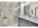 Bathroom with double sink vanity, tiled shower with glass door and bench at 6414 Stuart St, Arvada, CO 80003