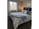 Comfortable bedroom features a large window, soft lighting, and stylish blue and white bedding set at 6414 Stuart St, Arvada, CO 80003