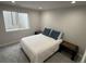 Comfortable bedroom features a queen bed, twin nightstands, neutral carpeting, and a window at 6414 Stuart St, Arvada, CO 80003