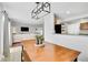 Dining area featuring wooden table, bench seating, and views of the living room and kitchen for seamless entertaining at 6414 Stuart St, Arvada, CO 80003