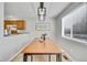 Cozy dining room with a wooden table, stylish light fixture, and a window offering natural light at 6414 Stuart St, Arvada, CO 80003