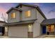 Two-story home featuring a beige exterior, attached garage, blue front door, and well-maintained landscaping at 6414 Stuart St, Arvada, CO 80003