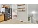 Kitchen with stainless steel refrigerator, light wood cabinetry, and access to the stairway at 6414 Stuart St, Arvada, CO 80003