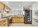 Functional kitchen featuring wood cabinets, stainless steel appliances, and a breakfast bar for casual dining and entertaining at 6414 Stuart St, Arvada, CO 80003