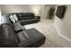 Comfortable living room features a sizable gray sectional couch, mounted TV, and neutral carpeting at 6414 Stuart St, Arvada, CO 80003
