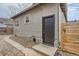 Rear exterior showcasing a dark door, contrasted by light stucco and tidy landscaping at 109 W Simpson St, Lafayette, CO 80026