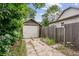 Backyard featuring a detached garage with overgrown landscaping, fence and driveway at 109 W Simpson St, Lafayette, CO 80026