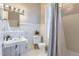 Bright bathroom featuring a pedestal sink, and a shower with window and striped shower curtain at 109 W Simpson St, Lafayette, CO 80026