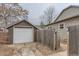 Detached garage featuring a white door, a wooden fence, and a concrete driveway at 109 W Simpson St, Lafayette, CO 80026