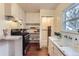 Functional kitchen featuring a gas range, vintage cabinetry, and hardwood floors at 109 W Simpson St, Lafayette, CO 80026