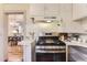 Bright kitchen showcases stainless steel range and white cabinets with an arched opening to dining area at 109 W Simpson St, Lafayette, CO 80026
