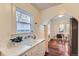 Charming kitchen with a vintage sink, white cabinets, and an arched doorway to the breakfast nook at 109 W Simpson St, Lafayette, CO 80026