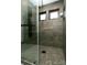 Sleek bathroom featuring a glass enclosed shower with mosaic tile flooring and gray walls at 9768 Otis Dr, Broomfield, CO 80021