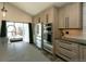 Modern kitchen featuring stainless steel appliances, bar seating, and sliding glass doors to the backyard at 9768 Otis Dr, Broomfield, CO 80021
