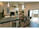 Open concept kitchen and living area with stainless steel appliances, island seating and backyard access at 9768 Otis Dr, Broomfield, CO 80021