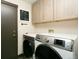 Convenient laundry area with modern washer and dryer, ample cabinet storage, and motivational wall decor at 9768 Otis Dr, Broomfield, CO 80021