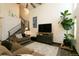 Comfortable living room featuring a sofa, TV, and staircase to the upper level at 9768 Otis Dr, Broomfield, CO 80021