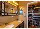This bathroom has double sinks with a granite countertop and access to the walk-in closet at 7661 Chickaree Ct, Littleton, CO 80125