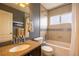 Well lit bathroom featuring a tub and shower combination, a single sink vanity, and a window at 7661 Chickaree Ct, Littleton, CO 80125