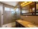 This bathroom has a tiled walk-in shower, double sinks, and a decorative vanity mirror at 7661 Chickaree Ct, Littleton, CO 80125