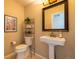 Cozy powder bathroom with pedestal sink, decorative mirror, and tiled floor at 7661 Chickaree Ct, Littleton, CO 80125