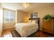 Bedroom with hardwood floors, ceiling fan, and window overlooking the yard at 7661 Chickaree Ct, Littleton, CO 80125
