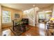 Dining room with hardwood floors, staircase, and views into the living room at 7661 Chickaree Ct, Littleton, CO 80125