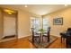 Dining area with hardwood floors, view of front yard, and a modern glass table at 7661 Chickaree Ct, Littleton, CO 80125