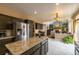 Open kitchen with granite counters, stainless appliances connects to the living room with fireplace at 7661 Chickaree Ct, Littleton, CO 80125