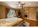 This main bedroom features hardwood floors, a ceiling fan, and a view of the en suite bathroom at 7661 Chickaree Ct, Littleton, CO 80125