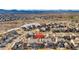 Stunning aerial view of the residential neighborhood with a vibrant red house and community features at 15980 Pikes Peak Dr, Broomfield, CO 80023