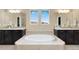 Bright bathroom featuring dual vanities, soaking tub, mosaic tile accents, and ample natural light at 15980 Pikes Peak Dr, Broomfield, CO 80023