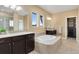Elegant bathroom with dual vanities, soaking tub, tiled accents, and a spacious walk-in closet at 15980 Pikes Peak Dr, Broomfield, CO 80023