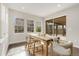 Bright dining space with a wooden table and direct access to a covered outdoor patio and a landscaped yard at 15980 Pikes Peak Dr, Broomfield, CO 80023