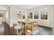 Sun-drenched dining room with wood floors features a rustic wooden table with seating for six and modern decor at 15980 Pikes Peak Dr, Broomfield, CO 80023