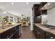 Modern kitchen featuring dark cabinets, granite countertops, and stainless steel appliances with open living concept at 15980 Pikes Peak Dr, Broomfield, CO 80023