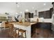 Open-concept kitchen with a large island, granite countertops, dark cabinets, and stainless steel appliances at 15980 Pikes Peak Dr, Broomfield, CO 80023