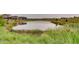 Scenic view of the community pond surrounded by lush greenery and residential homes at 15980 Pikes Peak Dr, Broomfield, CO 80023
